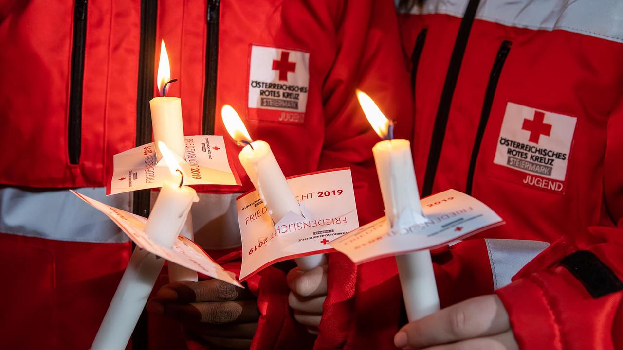 Mitarbeitende des Roten Kreuzes verteilen das ORF-Friedenslicht